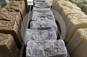 Multicolored handmade soap lies on the counter in rows