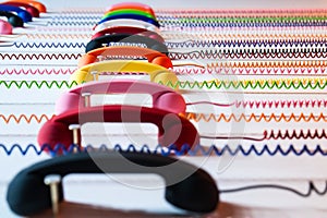 Multicolored handsets with spiral wire on a white background