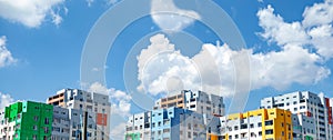 Multicolored houses panorama view. Blocked apartment buildings painted in vivid colors on blue sky background. Modern urban