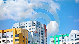 Multicolored houses panorama view. Blocked apartment buildings painted in vivid colors on blue sky background. Modern urban