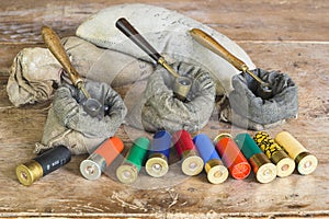 Multicolored hunting cartridges and many different bags with lead fractions and measure tools on old wooden background