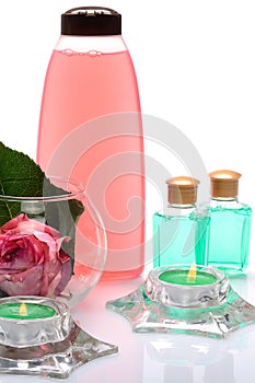 Multicolored items for baths, saunas, spa: shampoo, towels, flowers roses on a white background