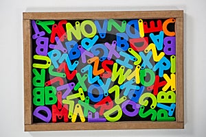 Multicolored Jumbled alphabets on slate board photo