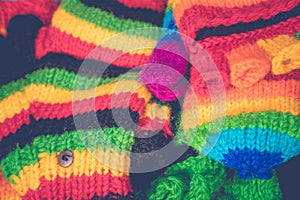 Multicolored knitted hand gloves for sale during Christmas market. Wool handicraft for protection in winter season