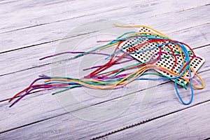 Multicolored laces for playing on the light wooden background.