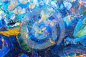 Multicolored large strokes of oil paint in blue, red and yellow shades on canvas, close up. Creative conception of