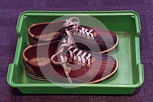 Multicolored leather shoes with laces, a pair, for playing bowling in a plastic tray