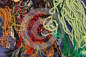 Multicolored lot of tasbeeh Tasbih beads. Huge amount of muslim prayer beads layeing on the table. Selling tasbeehs.