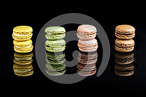 Multicolored macarons lined up on a black background