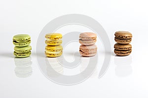 Multicolored macarons lined up on a white background