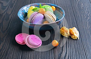 Multicolored macaroon cookies in a blue ceramic bowl