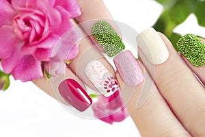 Multicolored manicure with flower.