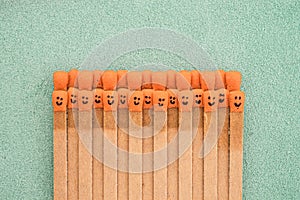 Multicolored matchsticks with faces painted on the heads with natural leather background