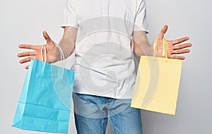 Multicolored packages in the hands of a man white t-shirt shopping studio