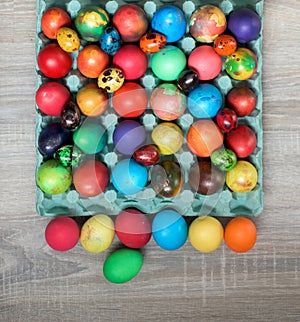 Multicolored painted hens and quail easter eggs in egg carton