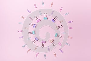 Multicolored paper clips in circle form on pink background Back to school concept with copy space for text