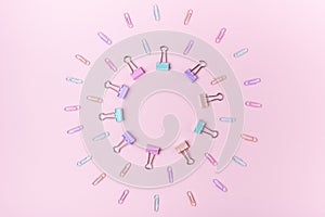 Multicolored paper clips in circle form on pink background Back to school concept with copy space for text
