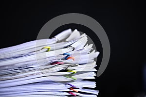 Multicolored paper clips on stack of paperwork