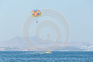 Multicolored parasail wing pulled by a boat.