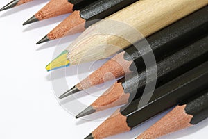 Multicolored pencil  in a group of black pencils