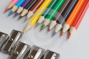 Multicolored pencils are located opposite the sharpeners.Creative concept.