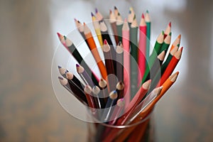 Multicolored pencils on the table. A stack of colored pencils ti