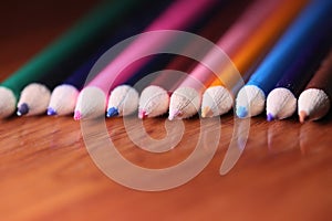 Multicolored pencils on the table. A stack of colored pencils ti