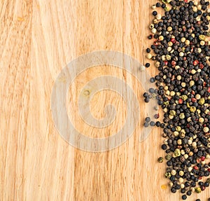 Multicolored Peppercorns on Wooden Background. Dry Peper Mix
