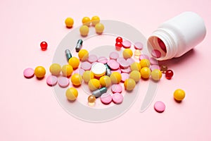 multicolored pills medicine pain reliever pink background