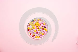 multicolored pills medicine pain reliever pink background