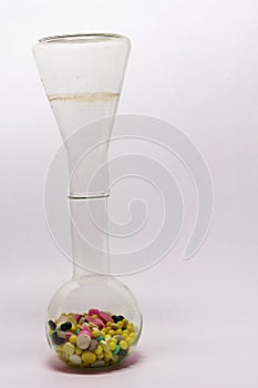 Multicolored pills, poured from upside down Erlenmeyer flask, th