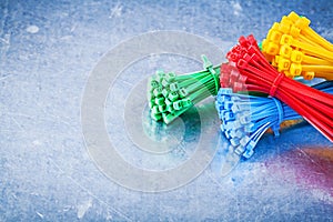 Multicolored plastic cable ties on metallic background construct