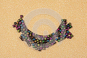 Multicolored plastic cube beads with letters scattered. background texture