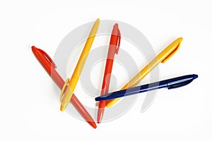 Multicolored plastic stationery pens on a white background