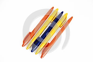 Multicolored plastic stationery pens on a white background