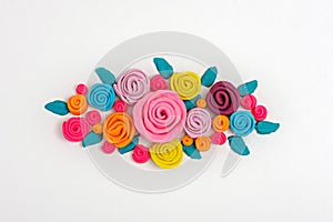 Multicolored plasticine flowers composition, bright roses on white background