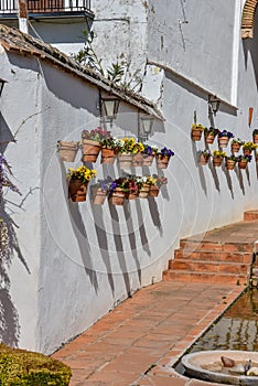 Multicolored pottery and flowers on a white wall in Spain