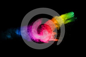 Multicolored powder explosion on black background.Color dust splash cloud on dark background.Launched colorful particles