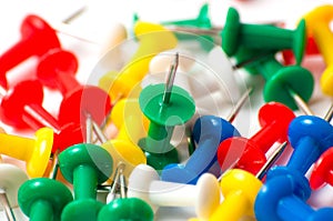 Multicolored push pins on awhite background close-up macro