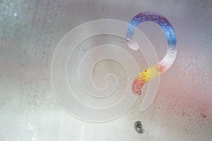 Multicolored question mark on the window glass background, toned