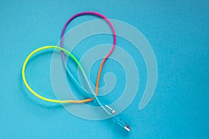 Multicolored rainbow USB cable for a smartphone on a blue background.
