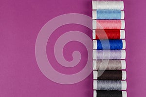 Multicolored Reels of Thread on a Purple Background