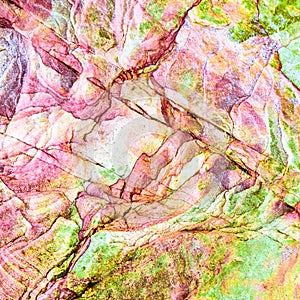 Multicolored rock wall from bottom sediments red orange dark rays crack smooth