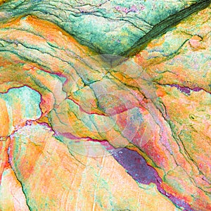 Multicolored rock wall from bottom sediments red orange dark rays crack smooth