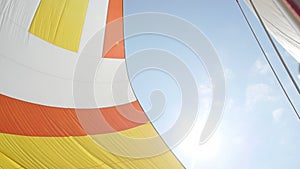 Multicolored Sail blows in wind on a boat.