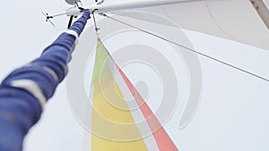 Multicolored Sail blows in wind on a boat.