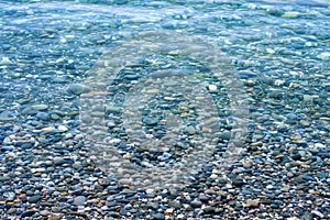 Multicolored sea pebbles in calm clear water