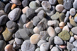 Multicolored sea pebbles evenly cover the beach surface Natural texture