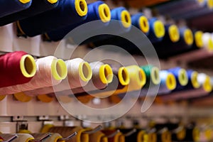 multicolored sewing threads bobbins on stand