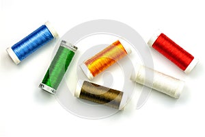 Multicolored sewing threads isolated on white background. Color thread spools on white background, top view